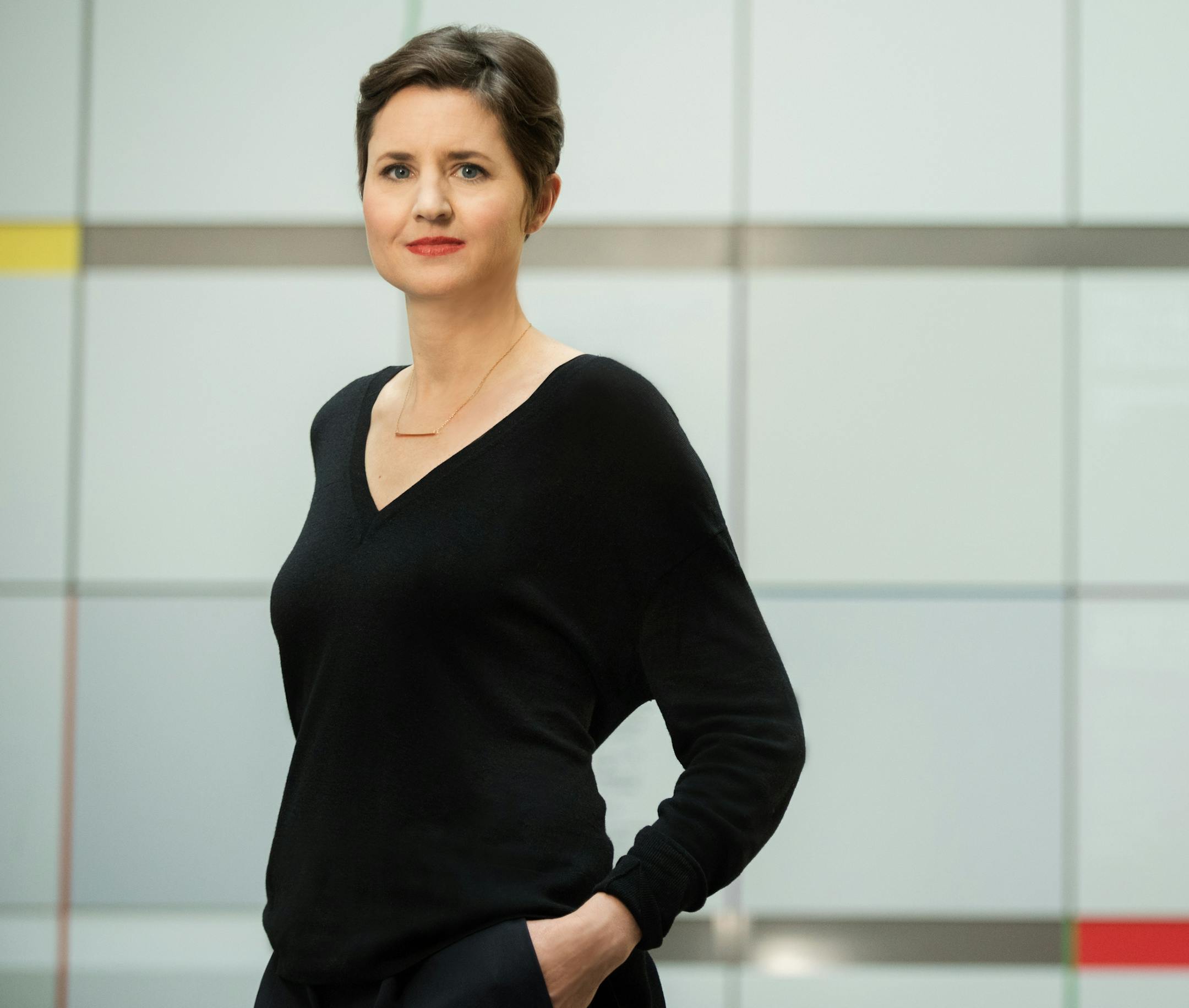 Henriette Huldisch, framed by the signature Kennth Noland painted-aluminum wall at the List Visual Arts Center in Cambridge, Mass.