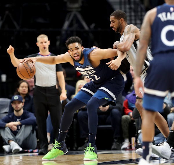 The Minnesota Timberwolves Karl-Anthony Towns (32) drives against the San Antonio Spurs' LaMarcus Aldridge (12) during the first half Friday, Jan. 18,