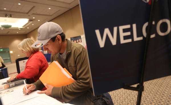 In this file photo, a man fills out an application at a job fair in Minneapolis.