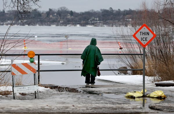 A pedestrian checks out the ice melt on Lake Harriet after a morning of warm temps and rain Friday, Feb. 19, 2016, in Minneapolis, MN.](DAVID JOLES/ST