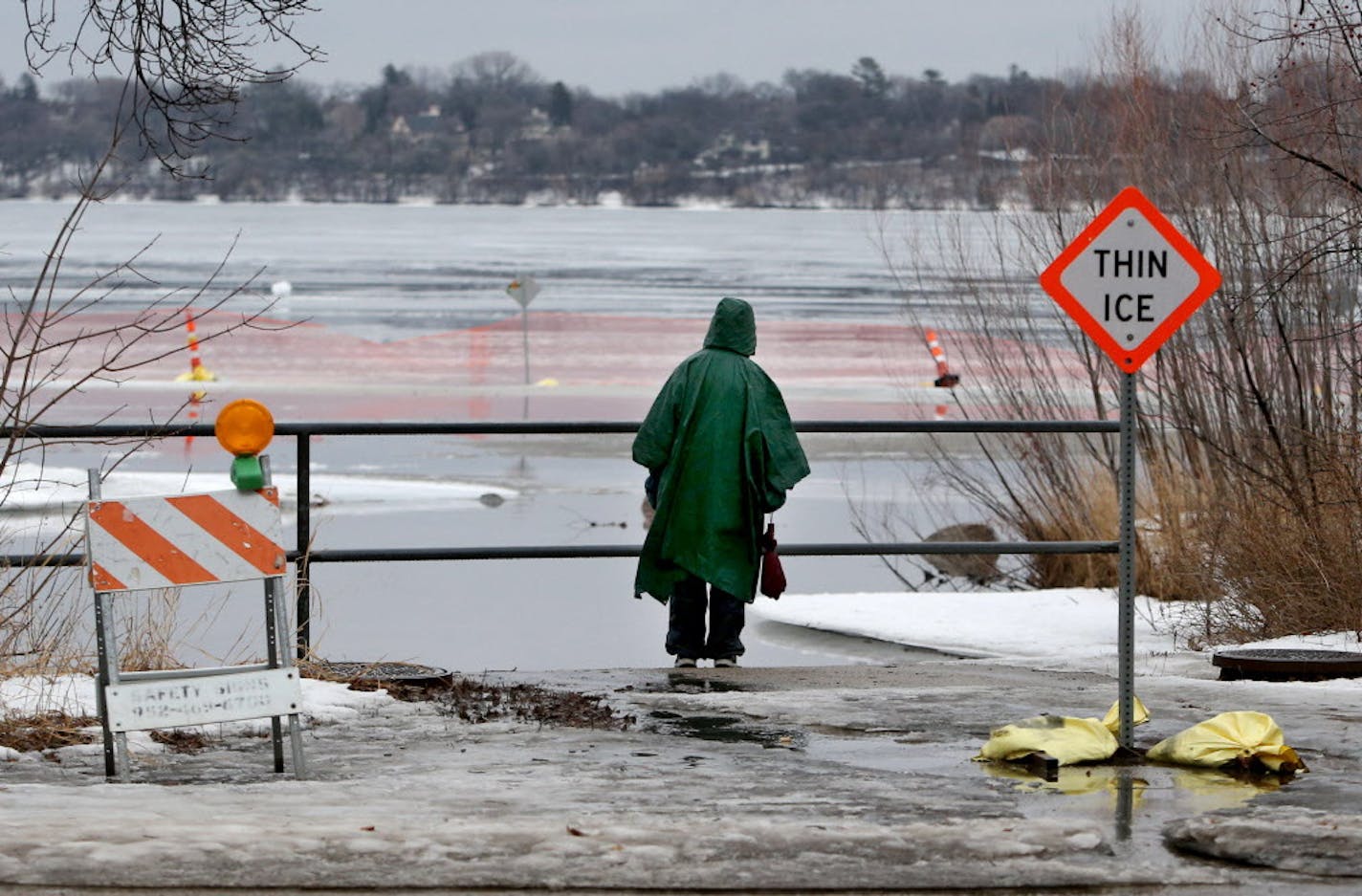 A pedestrian checks out the ice melt on Lake Harriet after a morning of warm temps and rain Friday, Feb. 19, 2016, in Minneapolis, MN.](DAVID JOLES/STARTRIBUNE)djoles@startribune.com Unusually warm, wet weather moved into the metro today and expected to stay unseasonably warm for the next few days. ORG XMIT: MIN1602191453550486