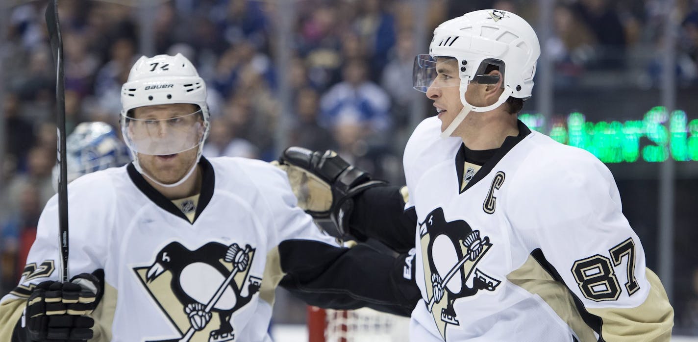 Pittsburgh Penguins Sidney Crosby, right, is congratulated by teammate Patric Hornqvist after scoring against the Toronto Maple Leafs during the first period of an NHL hockey game, Saturday, Oct. 11, 2014 in Toronto. (AP Photo/The Canadian Press, Frank Gunn