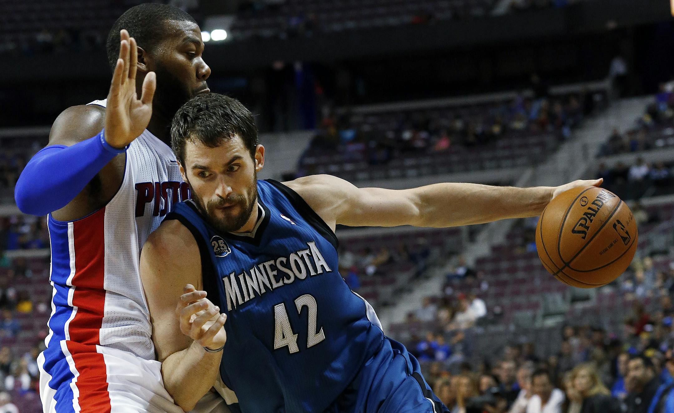 Minnesota Timberwolves power forward Kevin Love (42) drives against Detroit Pistons center Greg Monroe in the first half of their preseason NBA basketball game in Auburn Hills, Mich., Thursday, Oct. 24, 2013. (AP Photo/Paul Sancya)