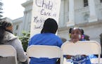 FILE - In this May 6, 2015, file photo Saryah Mitchell, sits with her mother, Teisa, Gay, left, a rally calling for increased child care subsidies at 