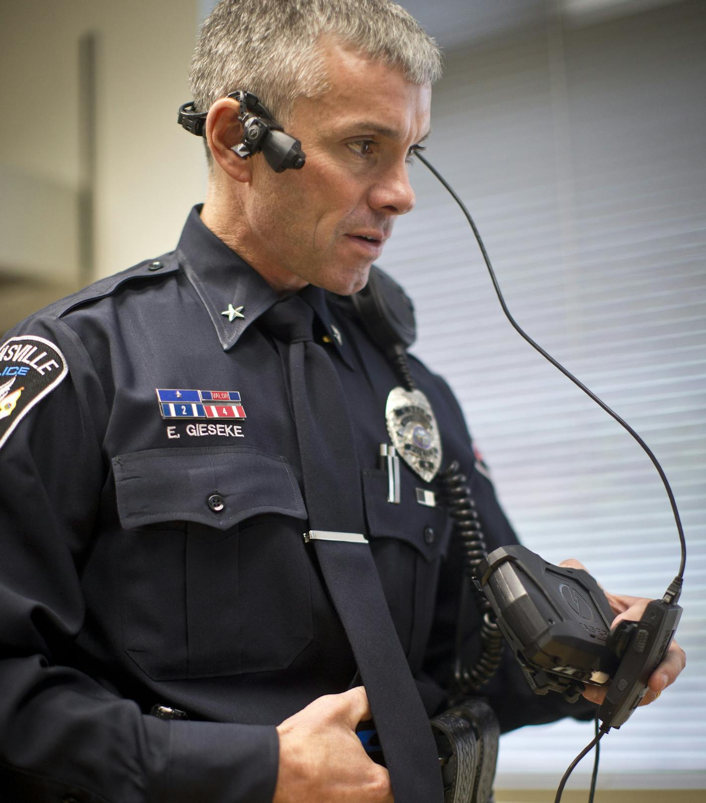 Worn on ear: Burnsville Police Chief Eric Gieseke demonstrated a different style of body-mounted camera this week. This one is worn over the ear and has a display screen that attaches to the belt. The cameras, used to improve conduct accountability, are slowly catching on in police departments in parts of Minnesota and across the nation.