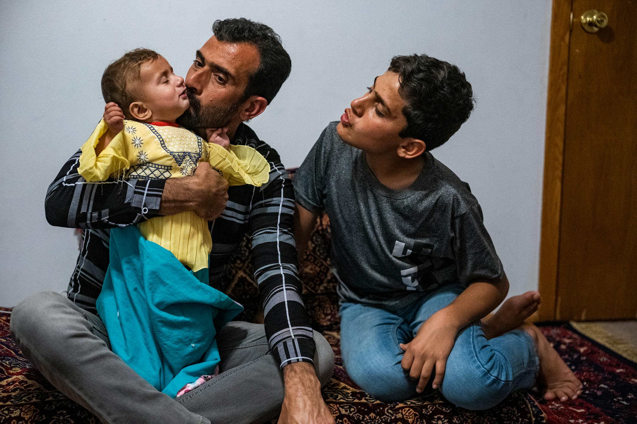 Mirwais Momand kisses Alia, nine months old as her brother Bilal,11, coos at her in Bloomington.