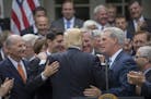 President Donald Trump is embraced by House Republican leaders as they came to the White House to celebrate the passage of the American Health Care Ac