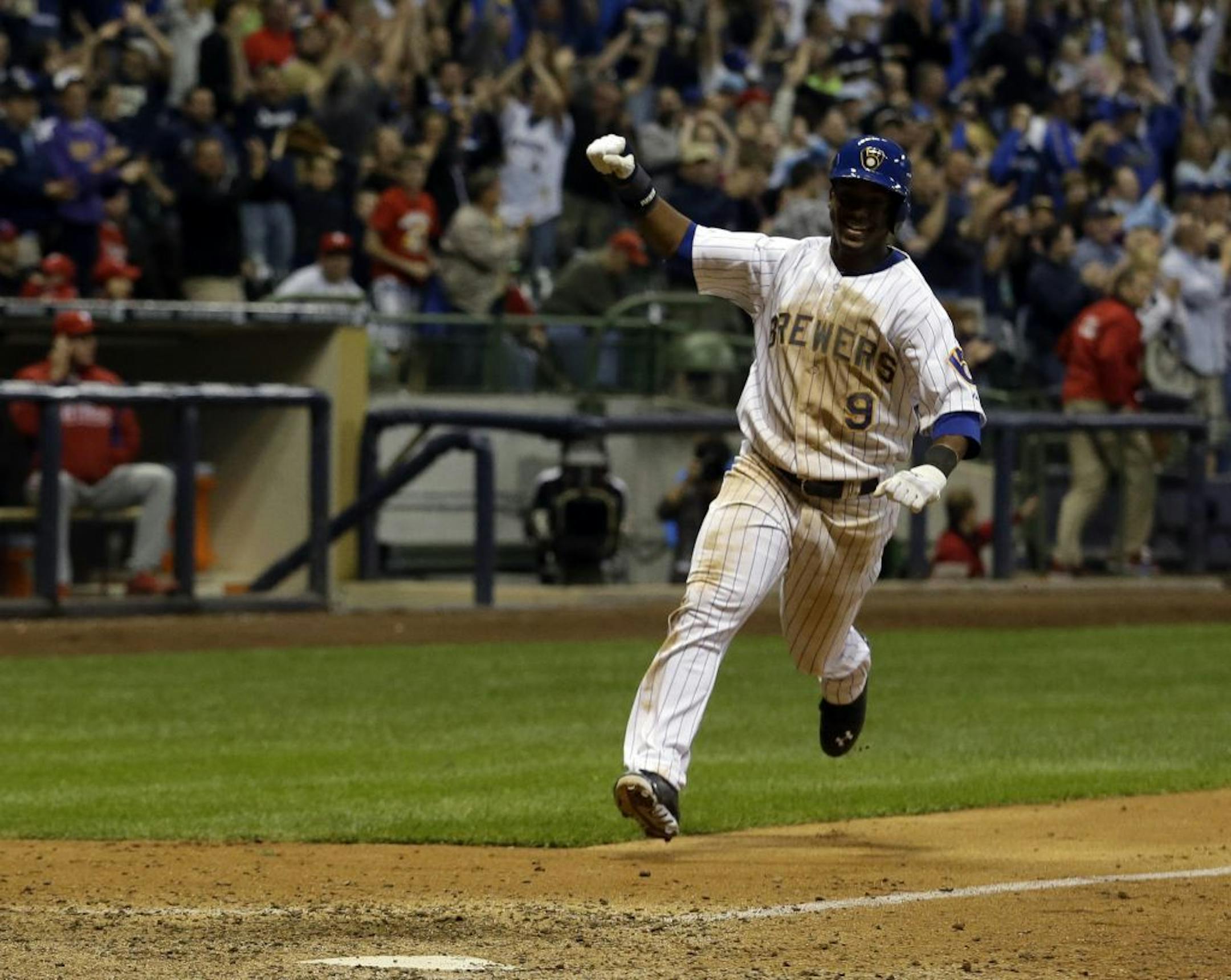 Milwaukee Brewers' Jean Segura reacts as he scores the game-winning run during the ninth inning of a baseball game against the Philadelphia Phillies Friday, June 7, 2013, in Milwaukee. The Brewers won 5-4.