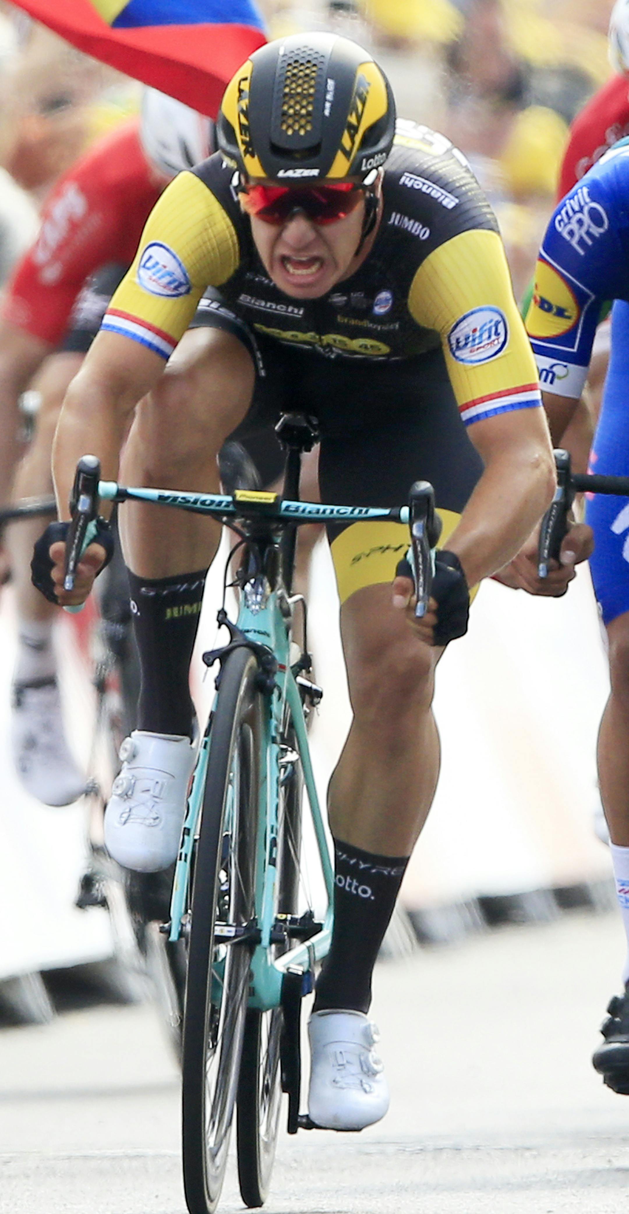 Netherlands' Dylan Groenewegen, left, crosses the finish line ahead of Colombia's Fernando Gaviria, center, to win the seventh stage of the Tour de France cycling race over 231 kilometers (143.5 miles) with start in Fougeres and finish in Chartres, France, France, Friday, July 13, 2018. (AP Photo/Peter Dejong)