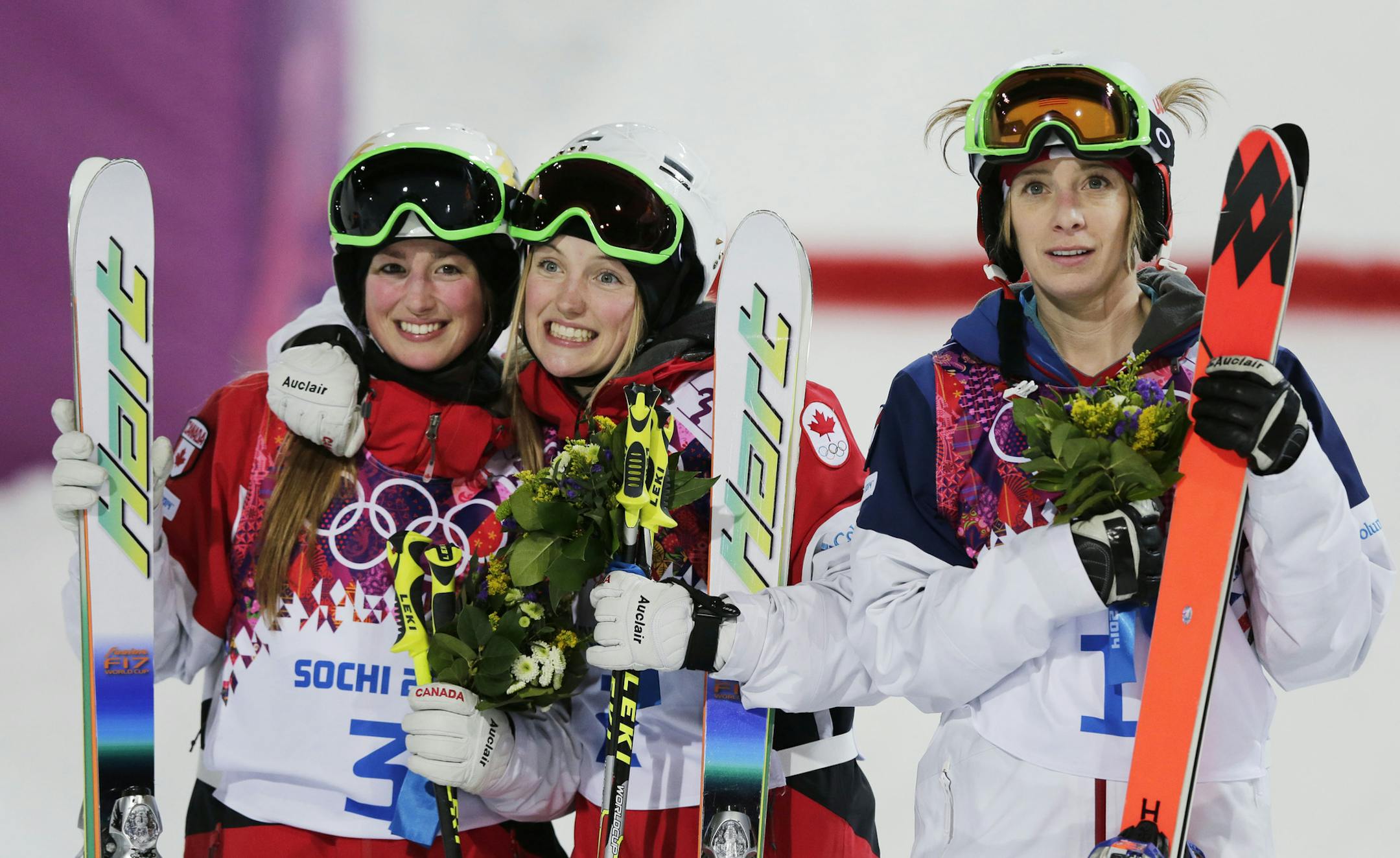 Canada's Justine Dufour-Lapointe, center, celebrates her gold medal in the women's moguls final, with her sister and silver medalist Chloe Dufour-Lapointe, left, and bronze medalist United States' Hannah Kearney at the 2014 Winter Olympics, Saturday, Feb. 8, 2014, in Krasnaya Polyana, Russia.