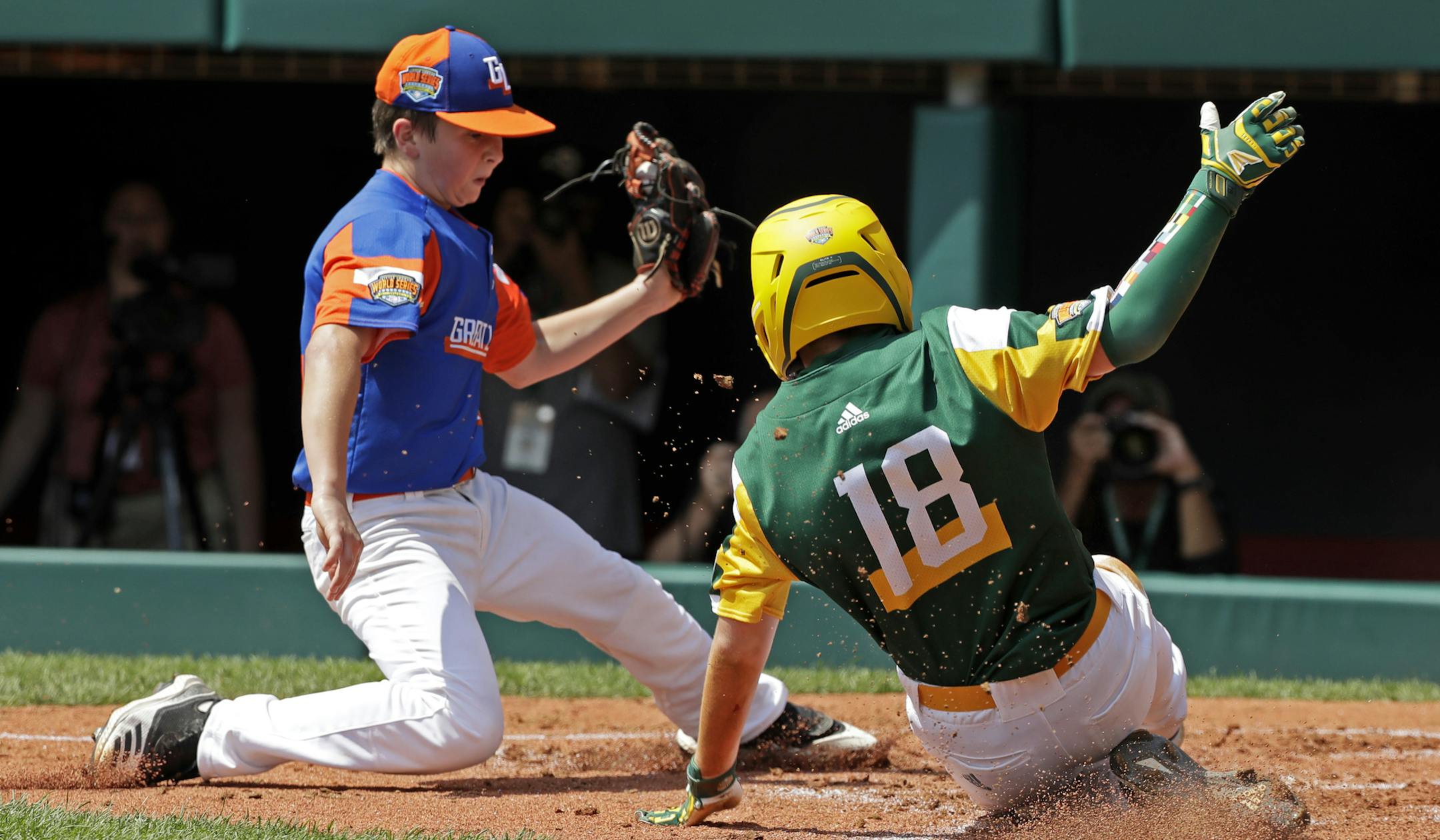 Coon Rapids, Minnesota's Tyler Phillips (18) scores ahead of the tag by Bowling Green, Kentucky's Grayson Newman during the second inning of a baseball game at the Little League World Series tournament in South Williamsport, Pa., Friday, Aug. 16, 2019. (AP Photo/Gene J. Puskar)
