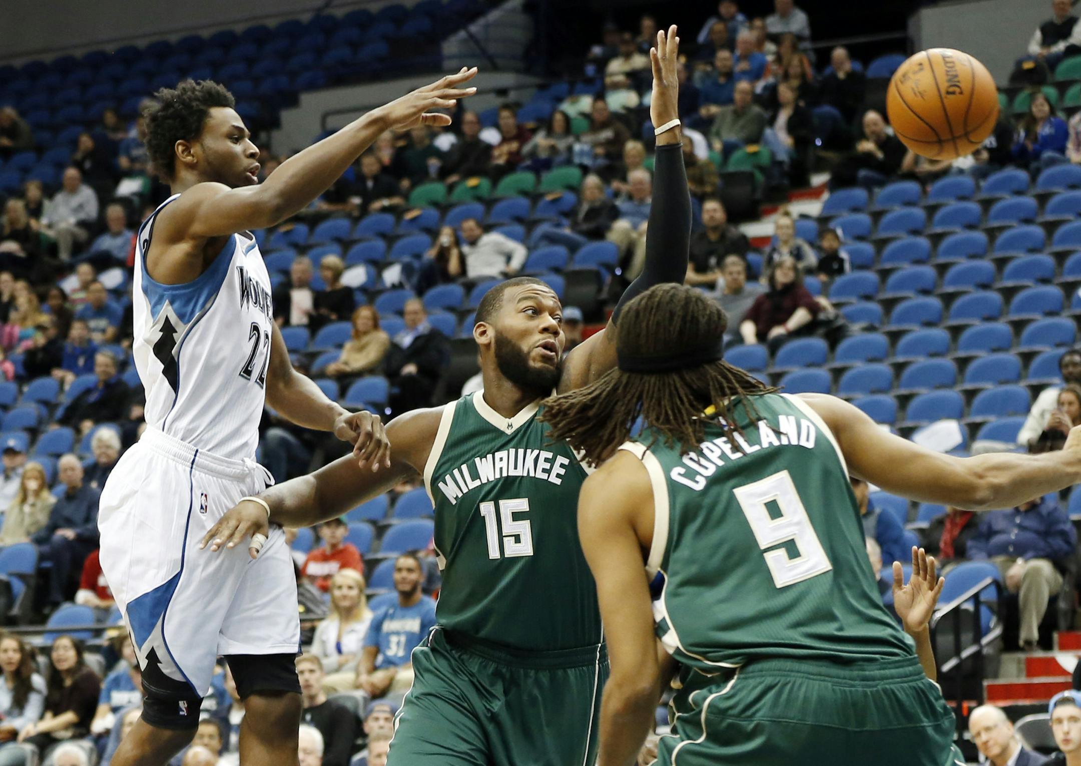 Minnesota Timberwolves’ Andrew Wiggins, left, makes a pass over Milwaukee Bucks’ Greg Monroe in the first half of an NBA preseason basketball game, Friday, Oct. 23, 2015, in Minneapolis. (AP Photo/Jim Mone)