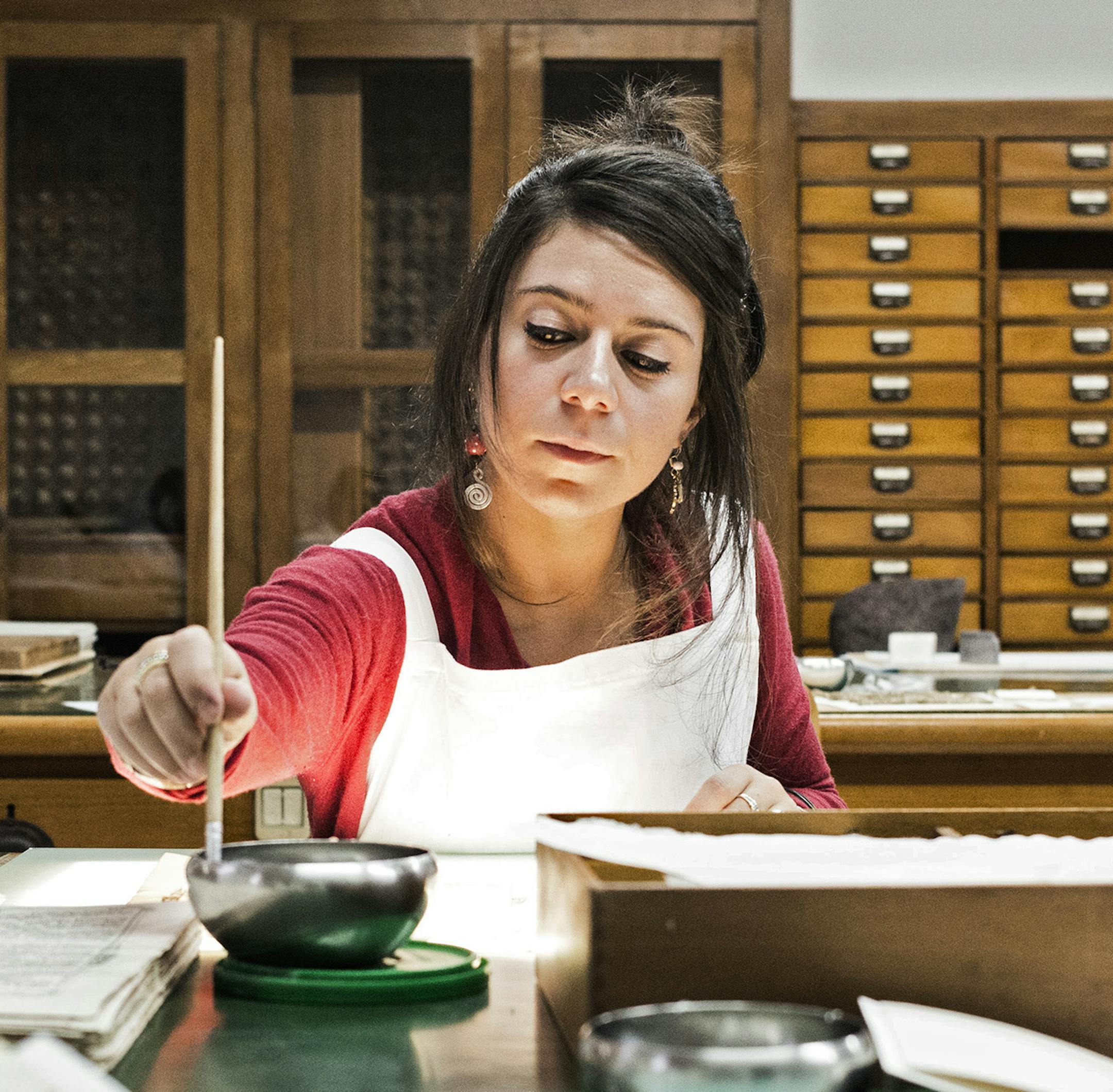 A restorer works on manuscripts from the Sacred Convent of St. Francis in Assisi, in the restoration laboratory at the Praia Abbey near Padua, Italy, Nov. 5, 2014. A collection of 19 artifacts, which includes 13 manuscripts, that are the most ancient documents of St. Francis’ life and theological tradition, will be at Brooklyn Borough Hall in early January in an exhibition, “Friar Francis: Traces, Words and Images.” (Alessandro Grassani/The New York Times)