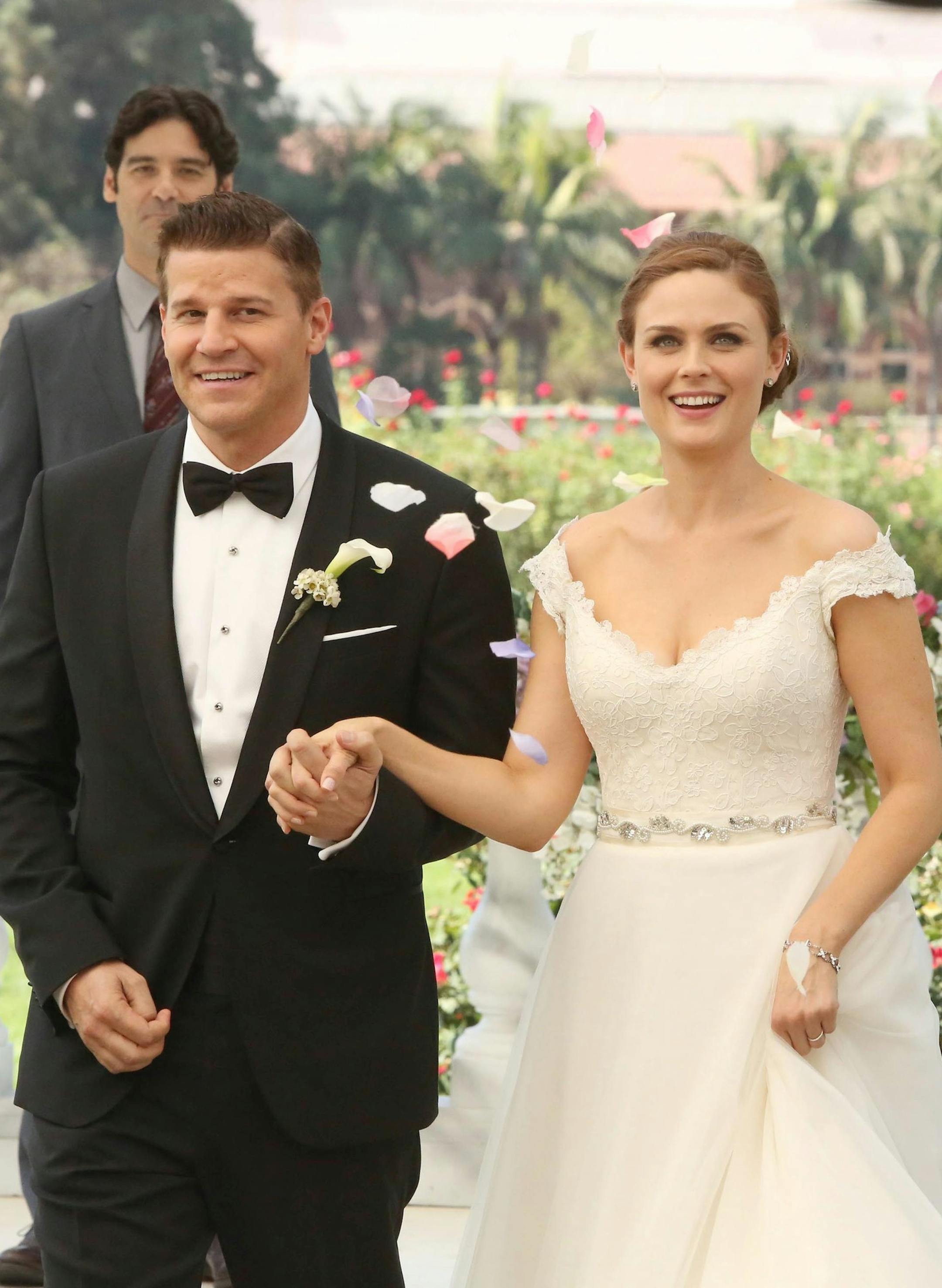 BONES: Brennan (Emily Deschanel, R) and Booth (David Boreanaz, L) at their wedding in the "The Woman in White" episode of BONES airing Monday, Oct. 21 (8:00-9:00 PM ET/PT) on FOX. Also pictured background L-R: guest star Ty Panitz, guest star Mather Zickel and Michaela Conlin. ©2013 Fox Broadcasting Co. Cr: Patrick McElhenney/FOX