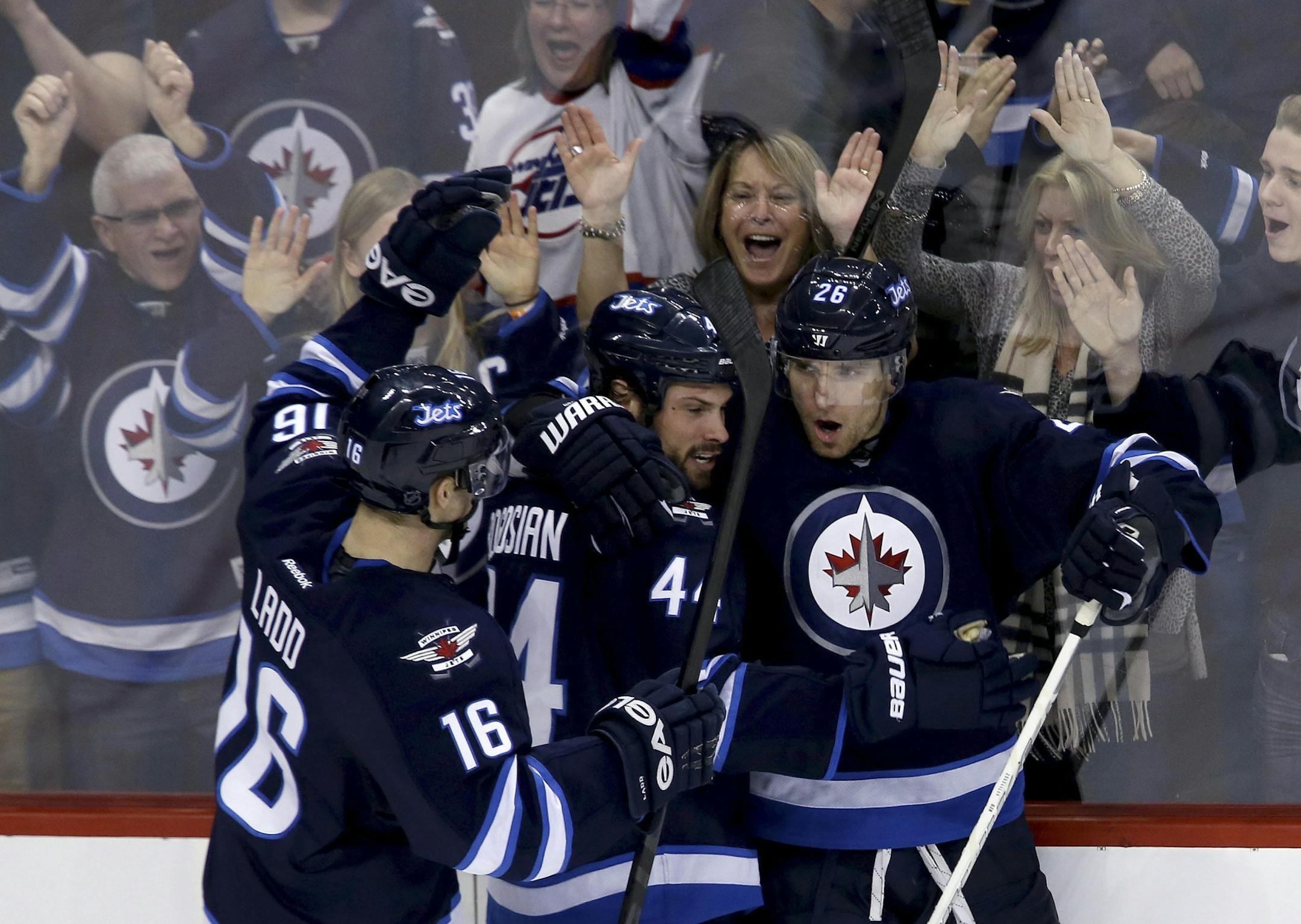Winnipeg Jets' Andrew Ladd, Zach Bogosian and Blake Wheeler, from left, celebrate Wheeler's goal against the Boston Bruins during the third period of an NHL hockey game Tuesday, March 19, 2013, in Winnipeg, Manitoba. Winnipeg won 3-1.
