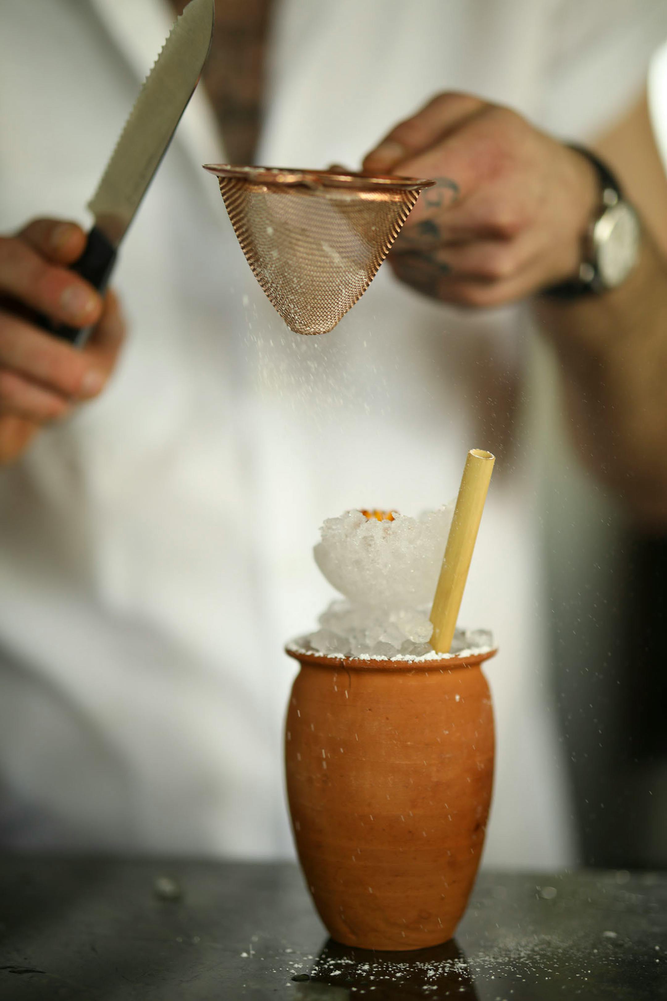 Martina's beverage director Marco Zappia dusted a "Toro y Gallo" cocktail with powdered sugar.