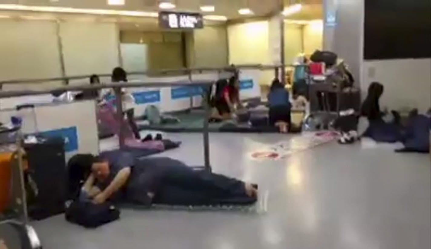 In this image made from video, stranded passengers lay on air mattresses at the Narita international airport in Narita outside Tokyo, early Tuesday, Aug. 9, 2016. Jeff Quigley, an American who lives in Japan and Indonesia, was one of thousands of passengers caught up in the worldwide Delta Air Lines shutdown. As day stretched into night, then overnight and the next morning, the 30-year-old venture capitalist posted live video updates on his Facebook page during what ended up being a nearly 20-ho