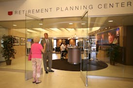 Retirement adviser Michael Rohweder speaks with a client in the entryway of the Retirement Planning Center in July 2007 in Edina.