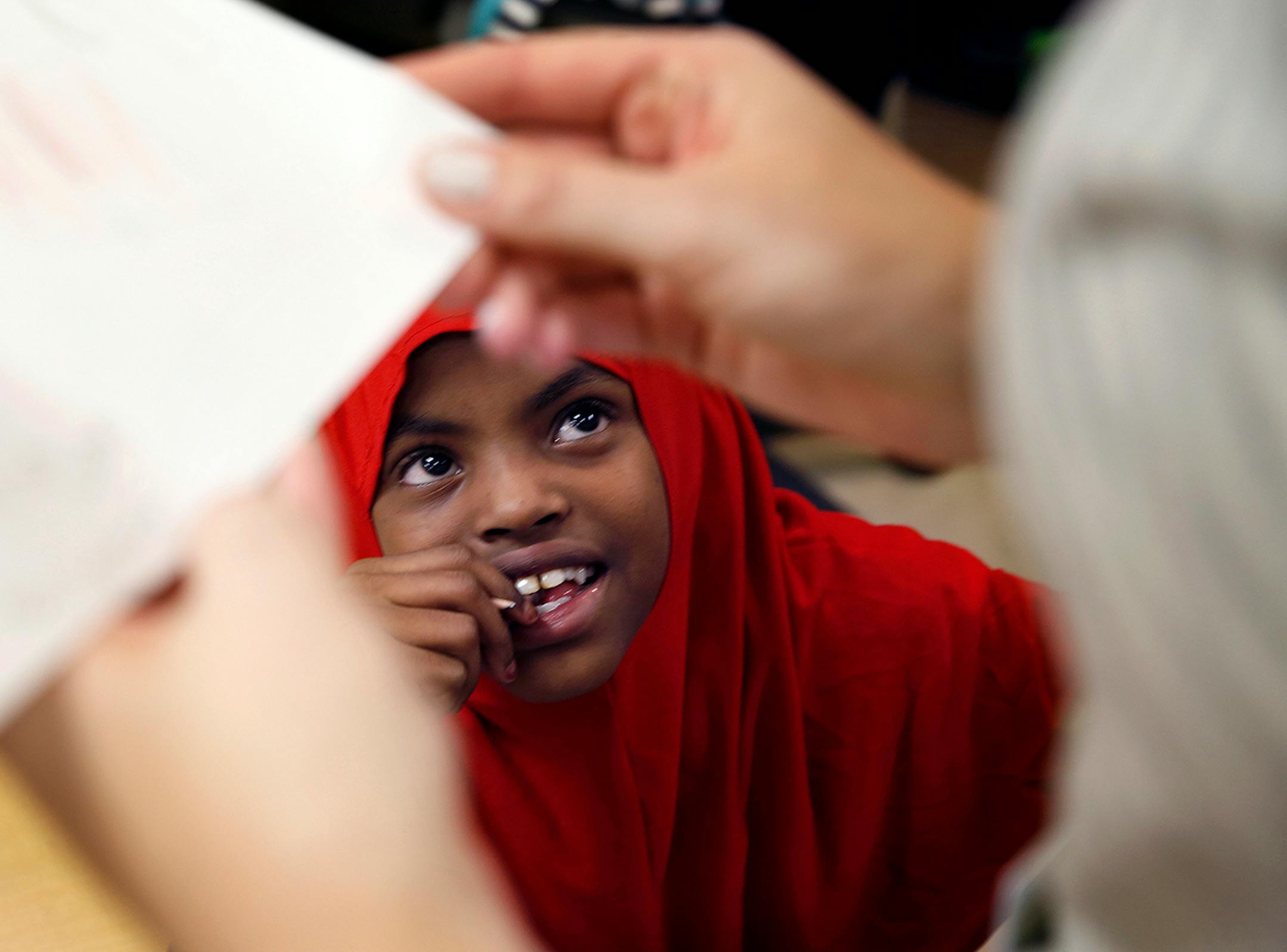 Yasmin Hassan, 9, gets feedback from the teacher during an English language development lesson in Stephany Jallo's classroom at Andersen United Community School in Minneapolis. ] LEILA NAVIDI leila.navidi@startribune.com / BACKGROUND INFORMATION: Tuesday, October 21, 2014. The Minneapolis school district launched a new program last school year with sheltered classrooms and instruction in both Somali and English for new refugee arrivals, many of whom come with little formal education.