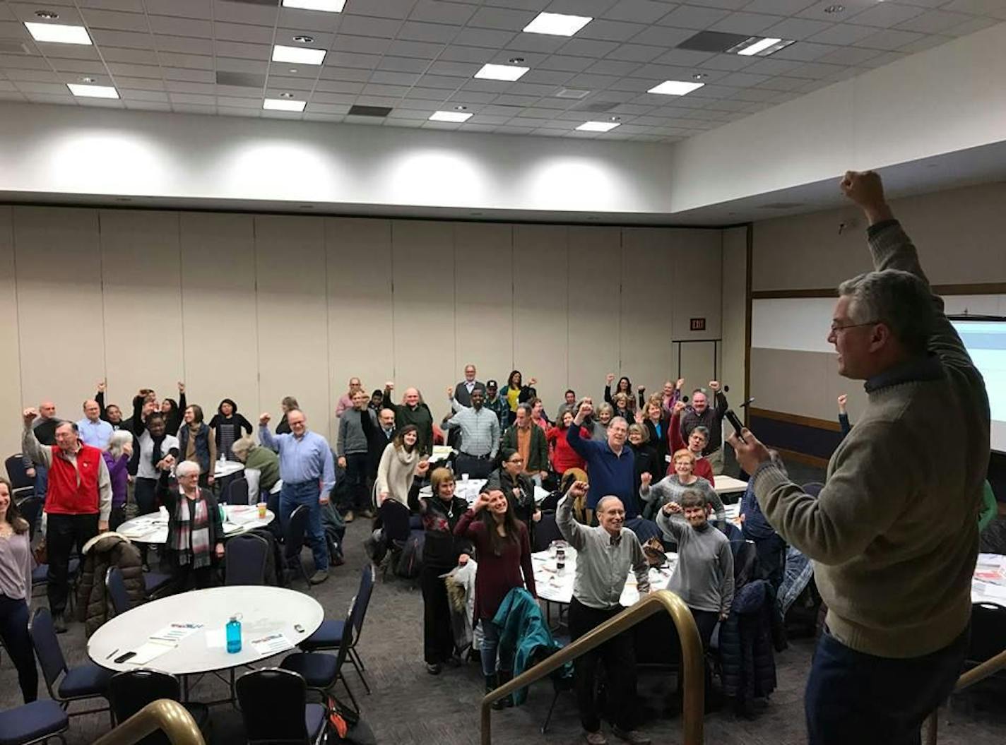 Members of the Suburban Hennepin Housing Coalition stood for a moment of solidarity during a meeting at the Adath Jeshurun Congregation in Minnetonka. The group works on behalf of low-income residents.