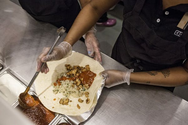 Employees prepare orders at a Chipotle restaurant in New York, April 23, 2015.