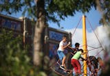 Kids played on the playground with a school mural behind them during the school's open house.