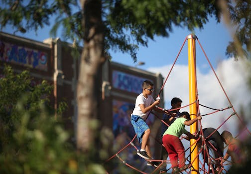 Kids played on the playground with a school mural behind them during the school's open house.