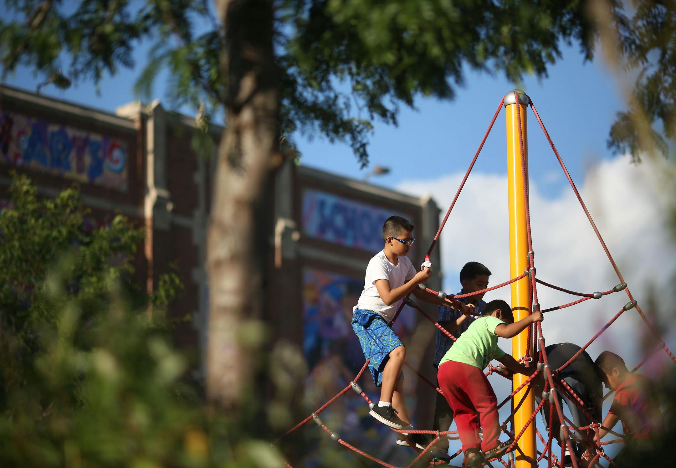 Kids played on the playground with a school mural behind them during the school's open house.