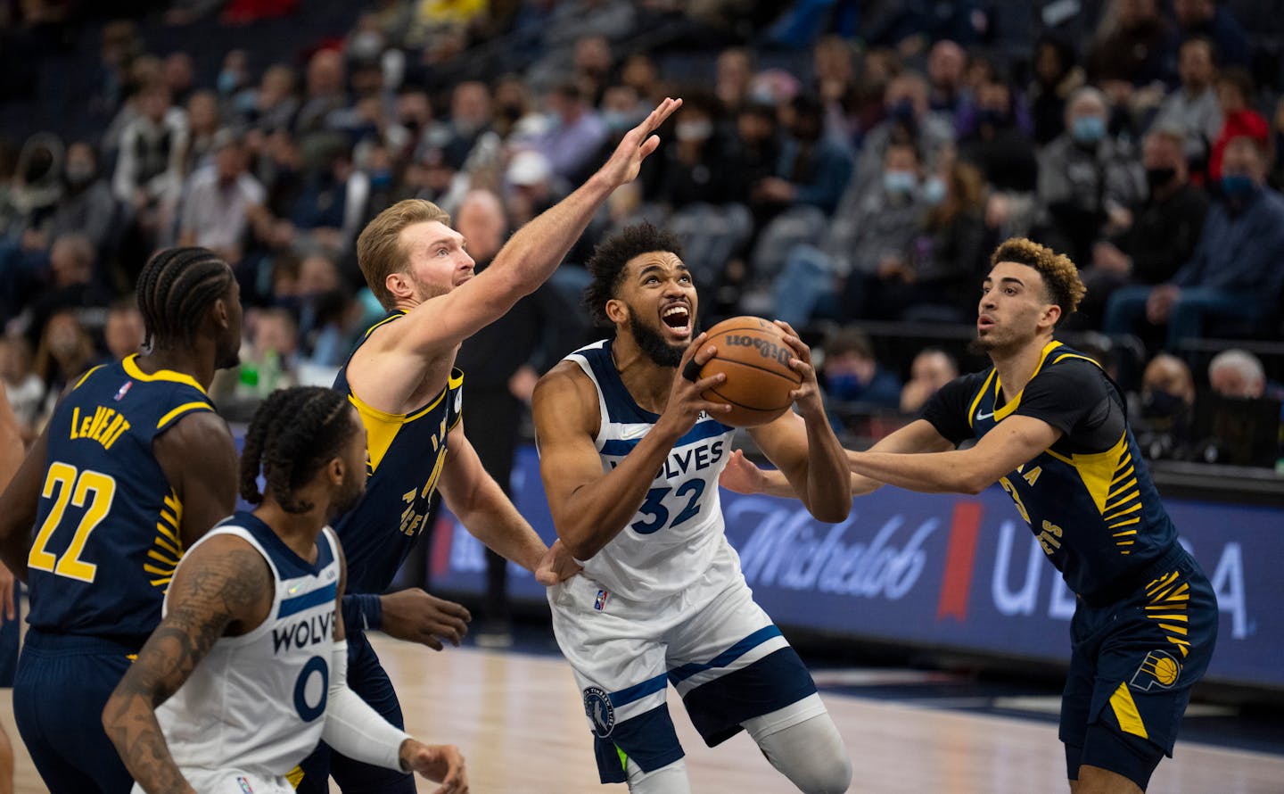 Minnesota Timberwolves center Karl-Anthony Towns (32) kept his eyes on the rim as he drove between Indiana Pacers forward Domantas Sabonis (11) and guard Chris Duarte (3) for a second quarter basket Monday, Nov. 29, 2021 in Minneapolis. The Minnesota Timberwolves met the Indiana Pacers in an NBA basketball game Monday, Nov. 29, 2021 night at Target Center in Minneapolis. ] JEFF WHEELER • Jeff.Wheeler@startribune.com