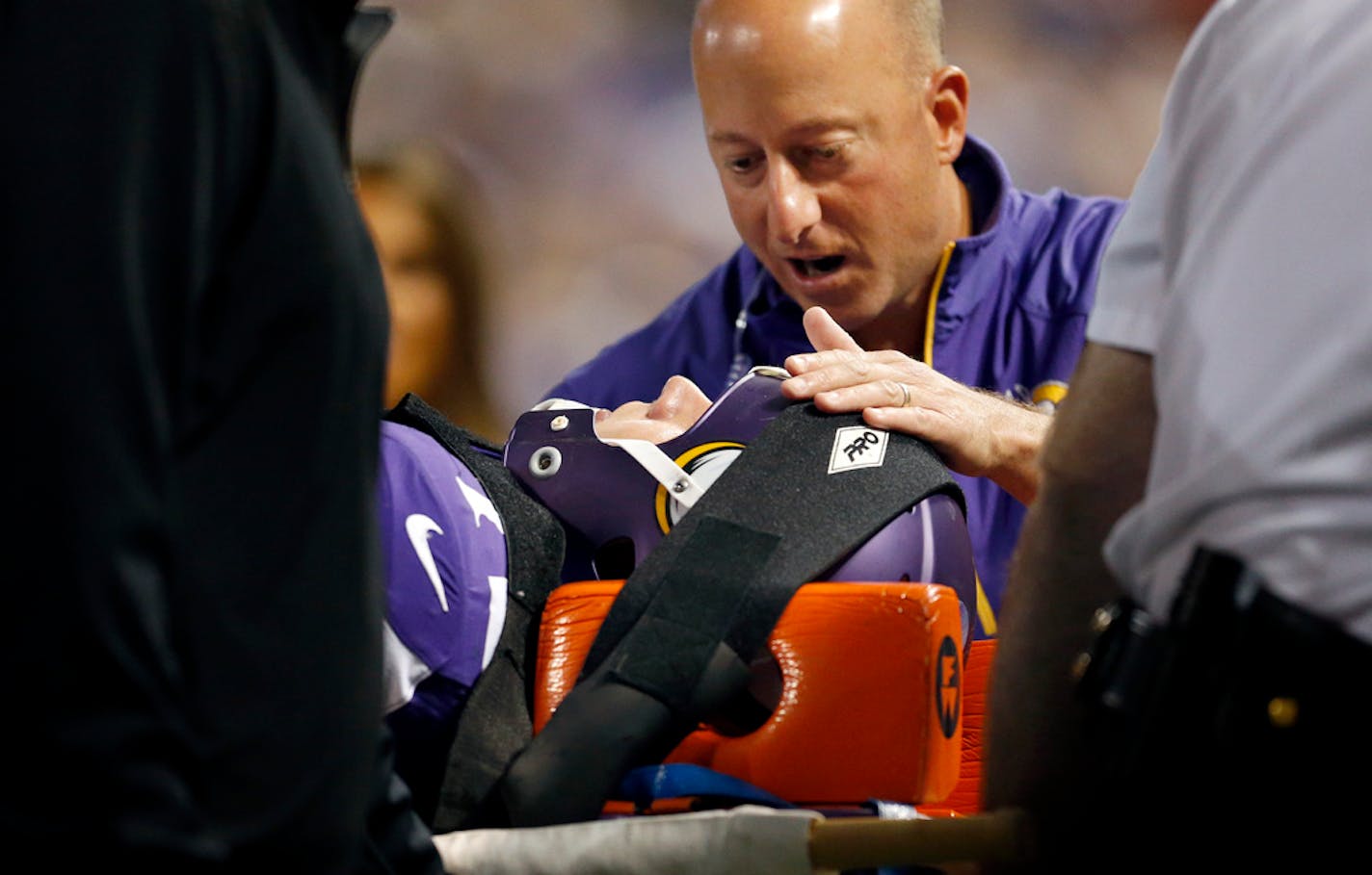 Minnesota Vikings head athletic trainer Eric Sugarman comforted offensive lineman Seth Olsen (72) as he was taken off the field in the second quarter.