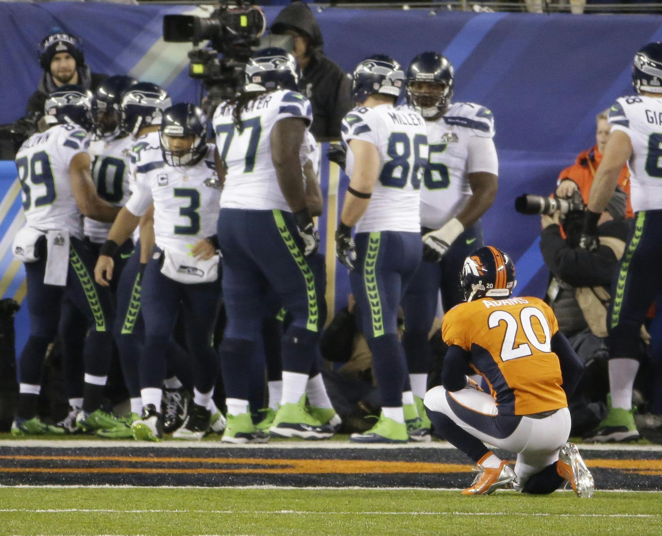 Mike Adams (20) of the Denver Broncos kneels on the field as the Seattle Seahawks celebrate a touchdown during the second half of Super Bowl XLVIII at MetLife Stadium in East Rutherford, N.J., on Sunday, Feb. 2, 2014. (J. Patric Schneider/MCT)