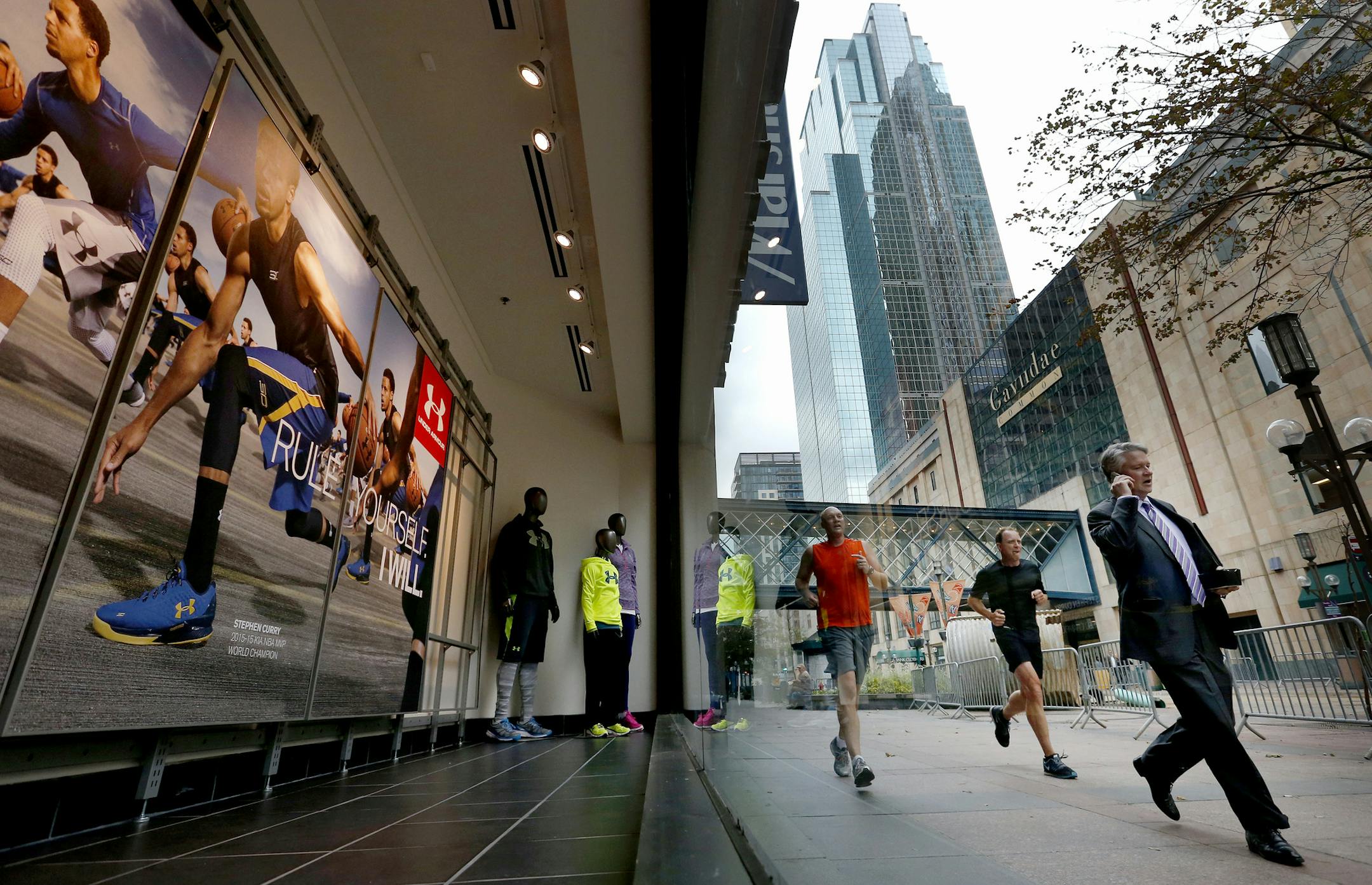 Pedestrians and runners passed a window display at the new Sports Authority downtown Minneapolis store on the Nicollet Mall. ] CARLOS GONZALEZ cgonzalez@startribune.com - October 8, 2015, Minneapolis, MN, Sports Authority opens its downtown Minneapolis store today (Oct. 9), following Walgreens, which did a soft opening a few weeks ago. How both stores are faring amid the Nicollet Mall construction.