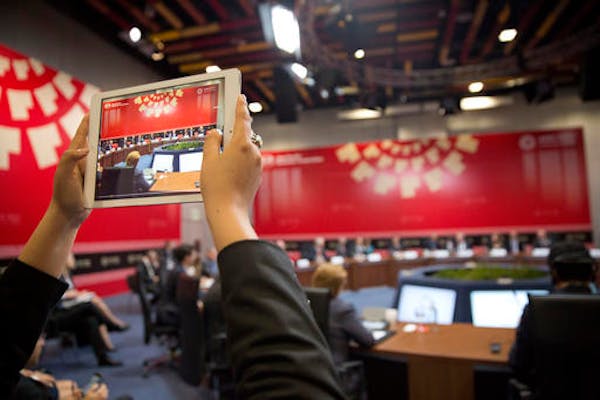 A member of the international media uses a tablet to record US President Barack Obama meeting with with leaders from Trans-Pacific Partnership (TPP), 
