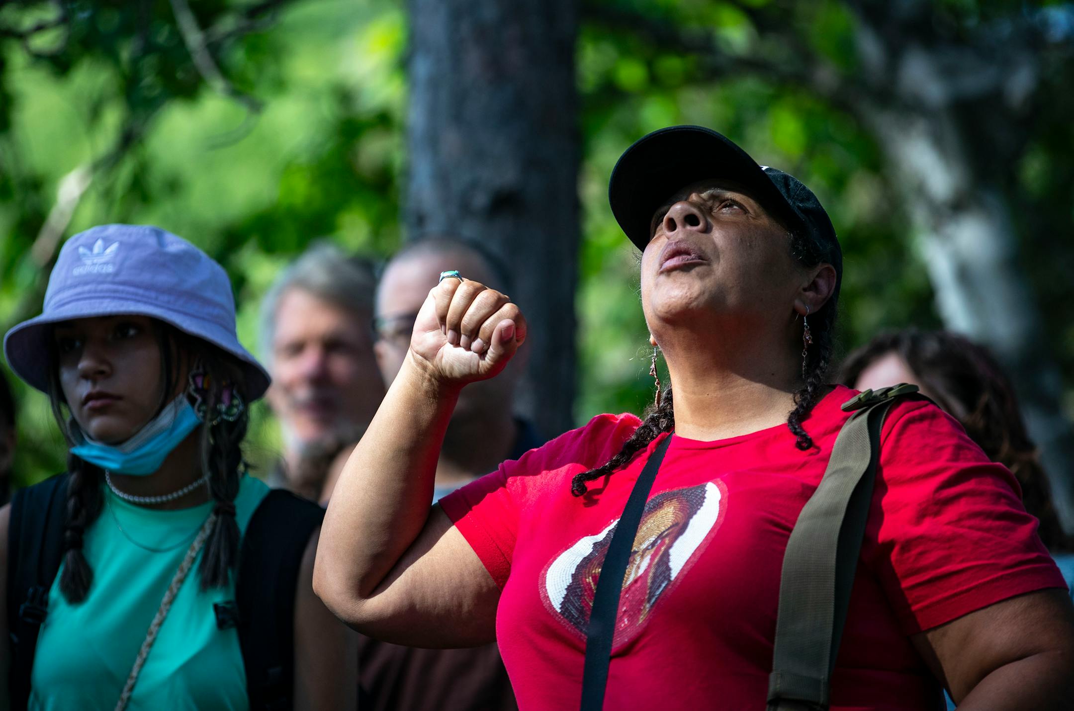 An indigenous woman raised her fist during an interfaith prayer circle at LaSalle Lake State Recreation Area on Monday morning.