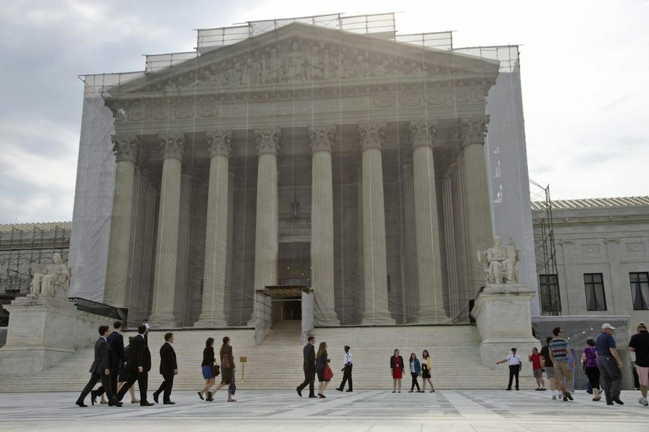 People wait outside the Supreme Court in anticipation of key decisions being announced, on Capitol Hill in Washington, Monday, June 17, 2013. With a week remaining in the current Supreme Court term, several major cases are still outstanding that could have widespread political impact on same-sex marriage, voting rights, and affirmative action.