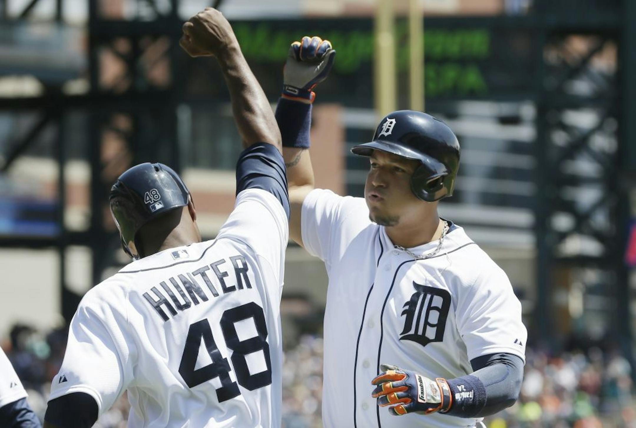 Detroit Tigers' Miguel Cabrera is congratulated by teammate Torii Hunter after they scored on Cabrera's 3-run home run during the second inning of a baseball game against the Minnesota Twins in Detroit, Saturday, May 10, 2014.