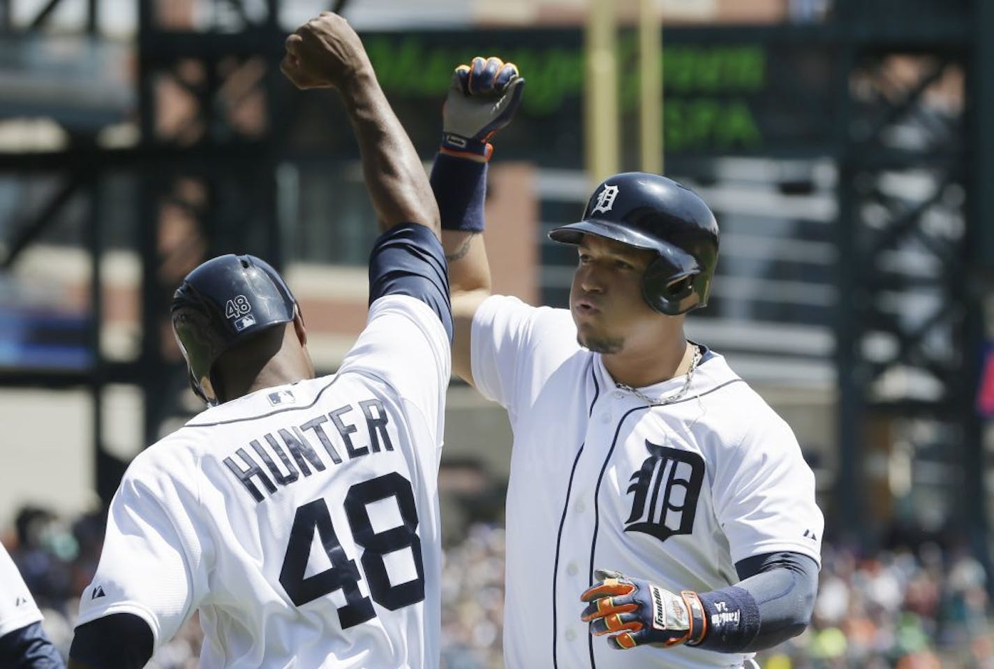 Detroit Tigers' Miguel Cabrera is congratulated by teammate Torii Hunter after they scored on Cabrera's 3-run home run during the second inning of a baseball game against the Minnesota Twins in Detroit, Saturday, May 10, 2014.