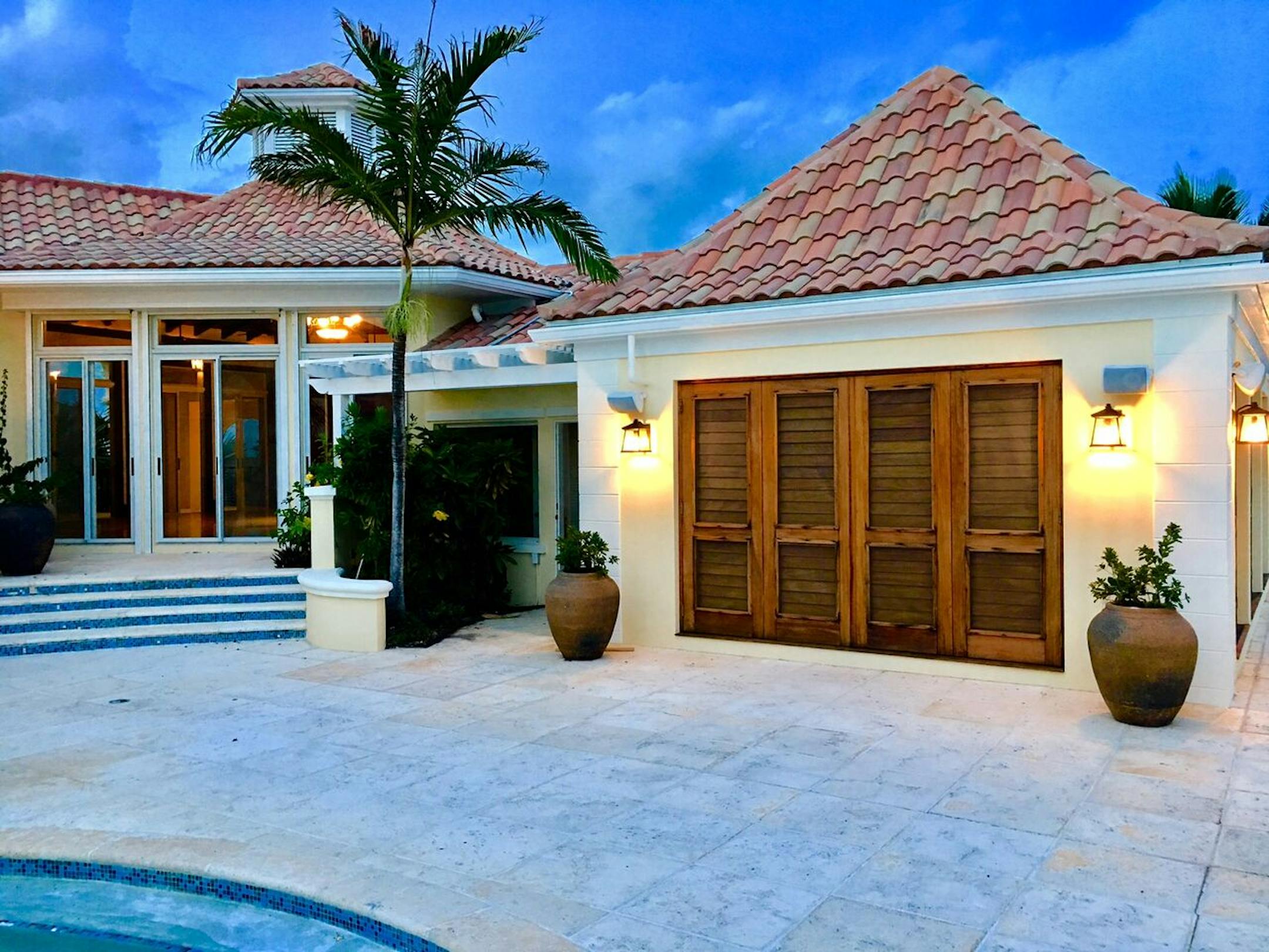 A tiled patio sits next to a pool (part of which can be seen in the lower right).