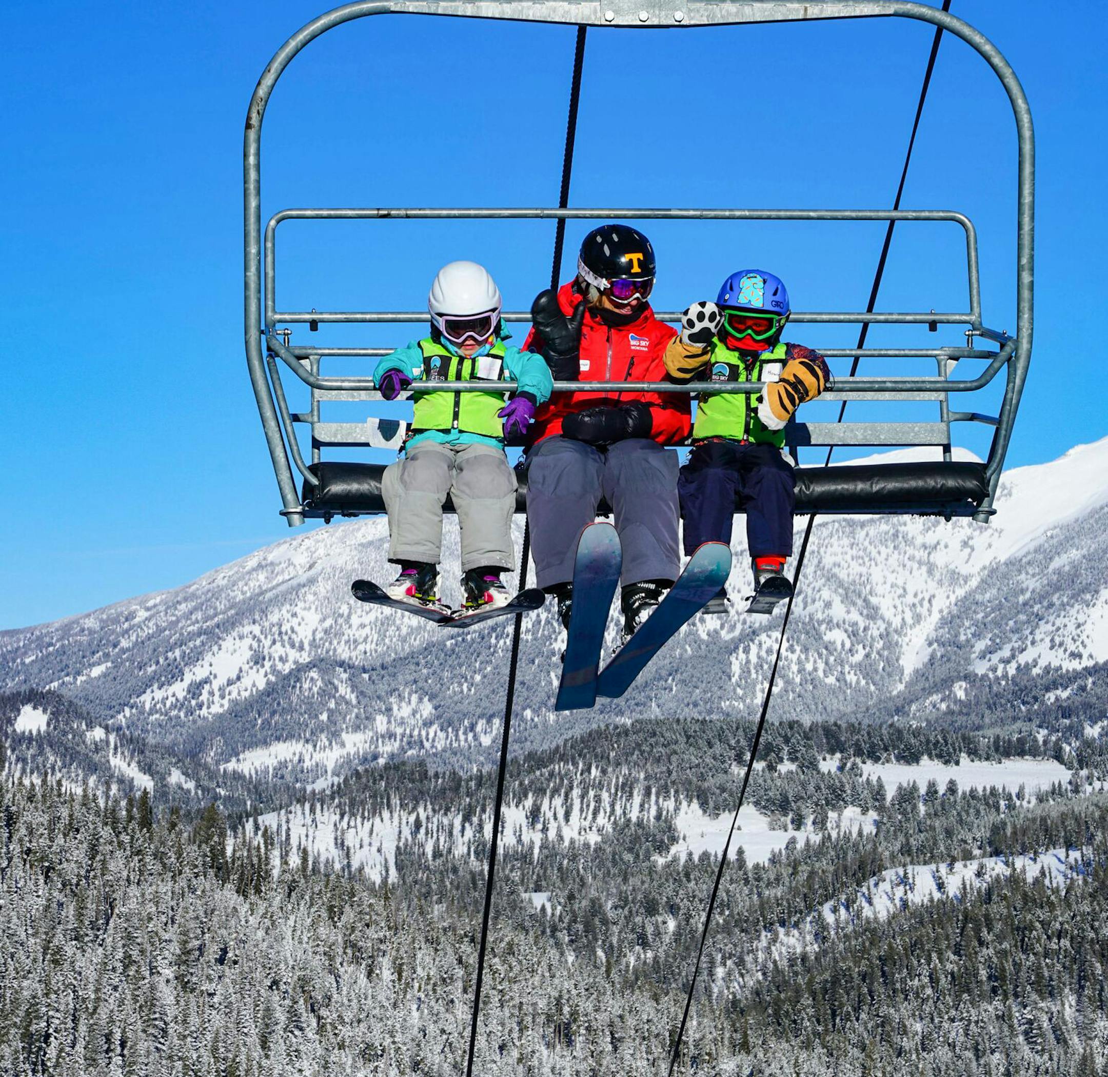 Young skiers wave from a chairlift at Big Sky in Montana. MUST CREDIT: Big Sky handout photo by Ed Coyle