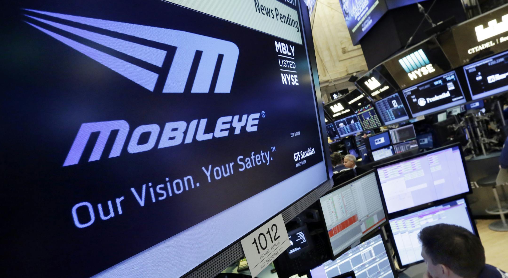 The Mobileye logo appears on a screen at the post where it trades on the floor of the New York Stock Exchange, Monday, March 13, 2017. Intel will buy Israel's Mobileye in a deal valued at just over $14 billion, the latest push by a major tech company to advance autonomous vehicles that could change the way traffic moves globally. (AP Photo/Richard Drew)
