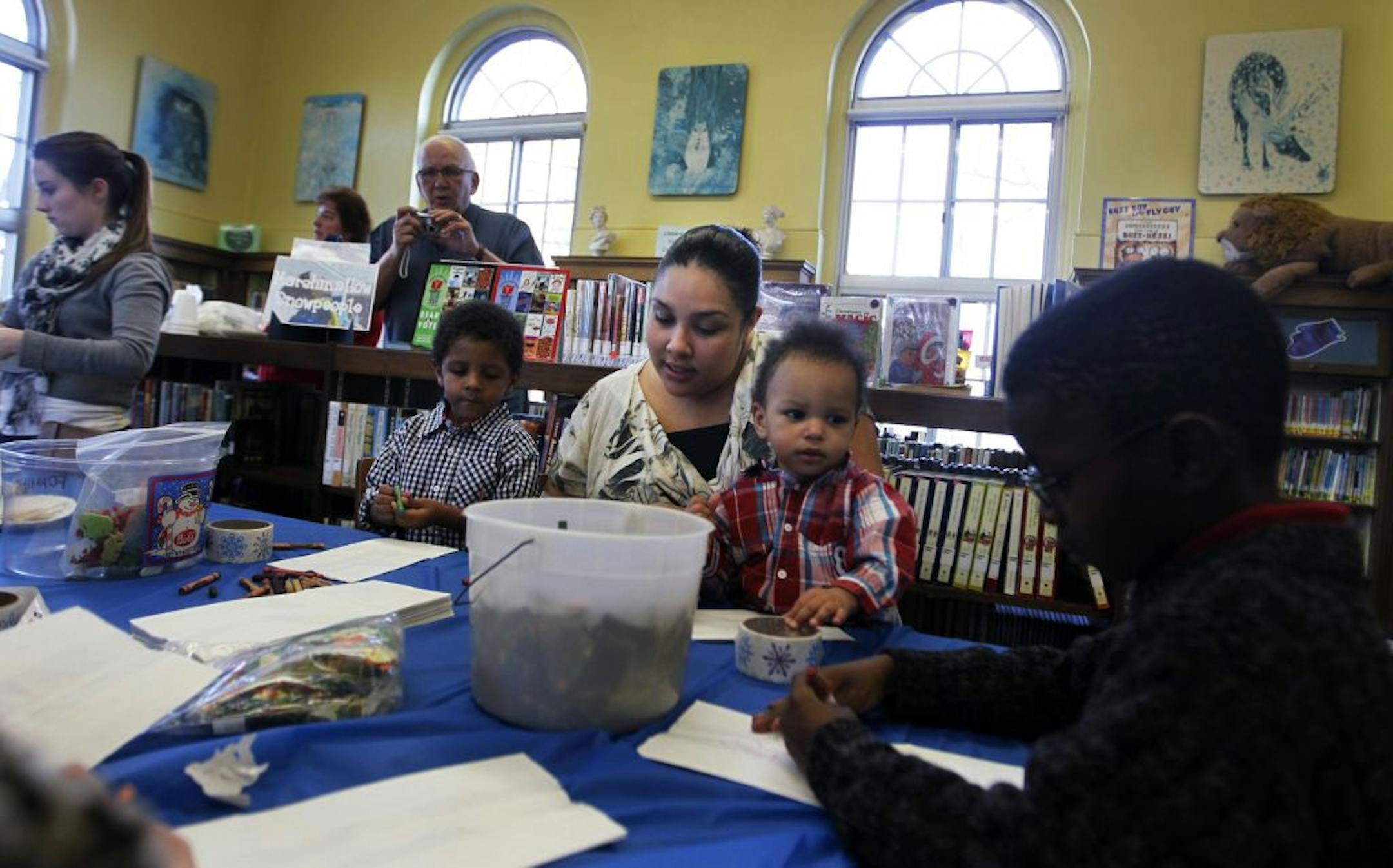 At the South St. Paul Public Library, children made snowman treats out of marshmallow, candy, and frosting at the Winter Wonderland event. Mother Jasmyne Hamilton held her 16-month old son Treyson Williams as her other son Taurean(3)sat next to her. On the far right is David Mikel(6) from Illinois who is visiting his grandfather.