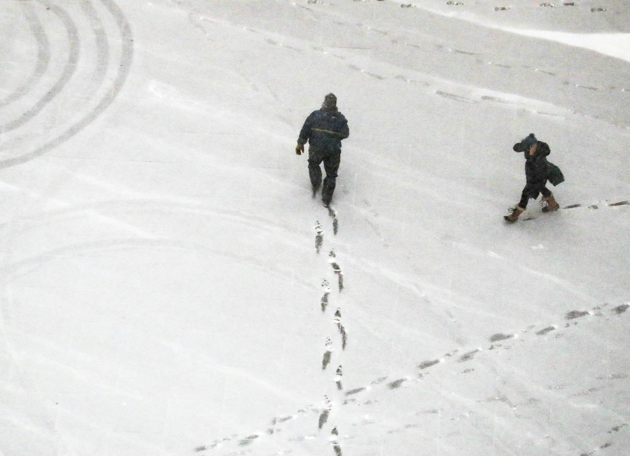 Pedestrians leave foot prints behind while navigating fresh snow near the US Bank Plaza Thursday, Jan 11, 2018, in Minneapolis, MN.] DAVID JOLES &#xd4; david.joles@startribune.com weather ORG XMIT: MIN1801111340182518