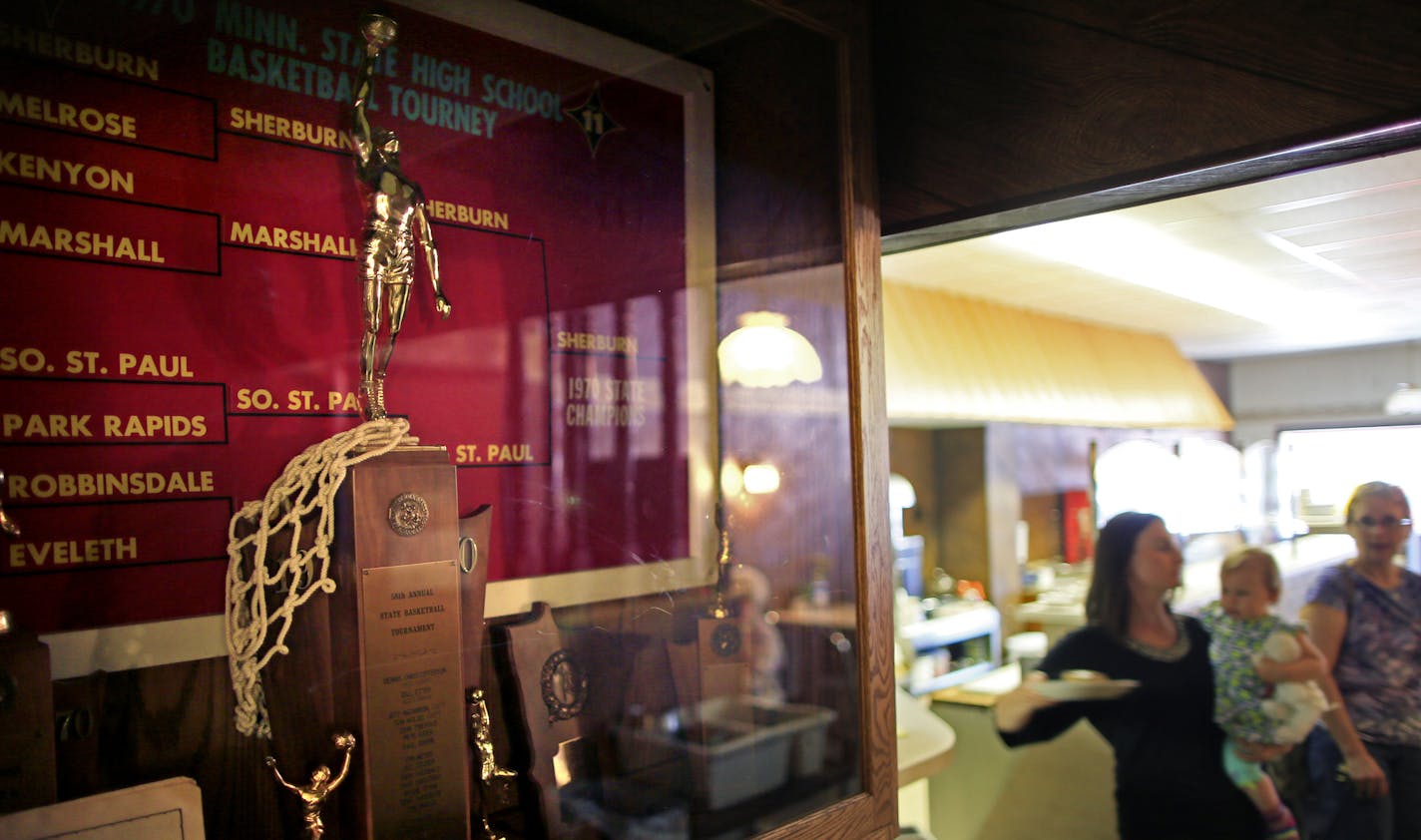 Twin Cities couple Seth and Elizabeth Lintelman won ownership of a Sherburn, Minn. cafe through a national essay writing contest. The Cup N' Saucer is the heart of Sherburn, and the new owners hope to continue that vibrancy. Here the Cup N' Saucer holds the trophy case for the pride of the Sherburn community, a first place trophy for boys high school basketball in 1970. ] BRIAN PETERSON &#xe2;&#x20ac;&#xa2; brianp@startribune.com Sherburn, MN - 06/14/2013