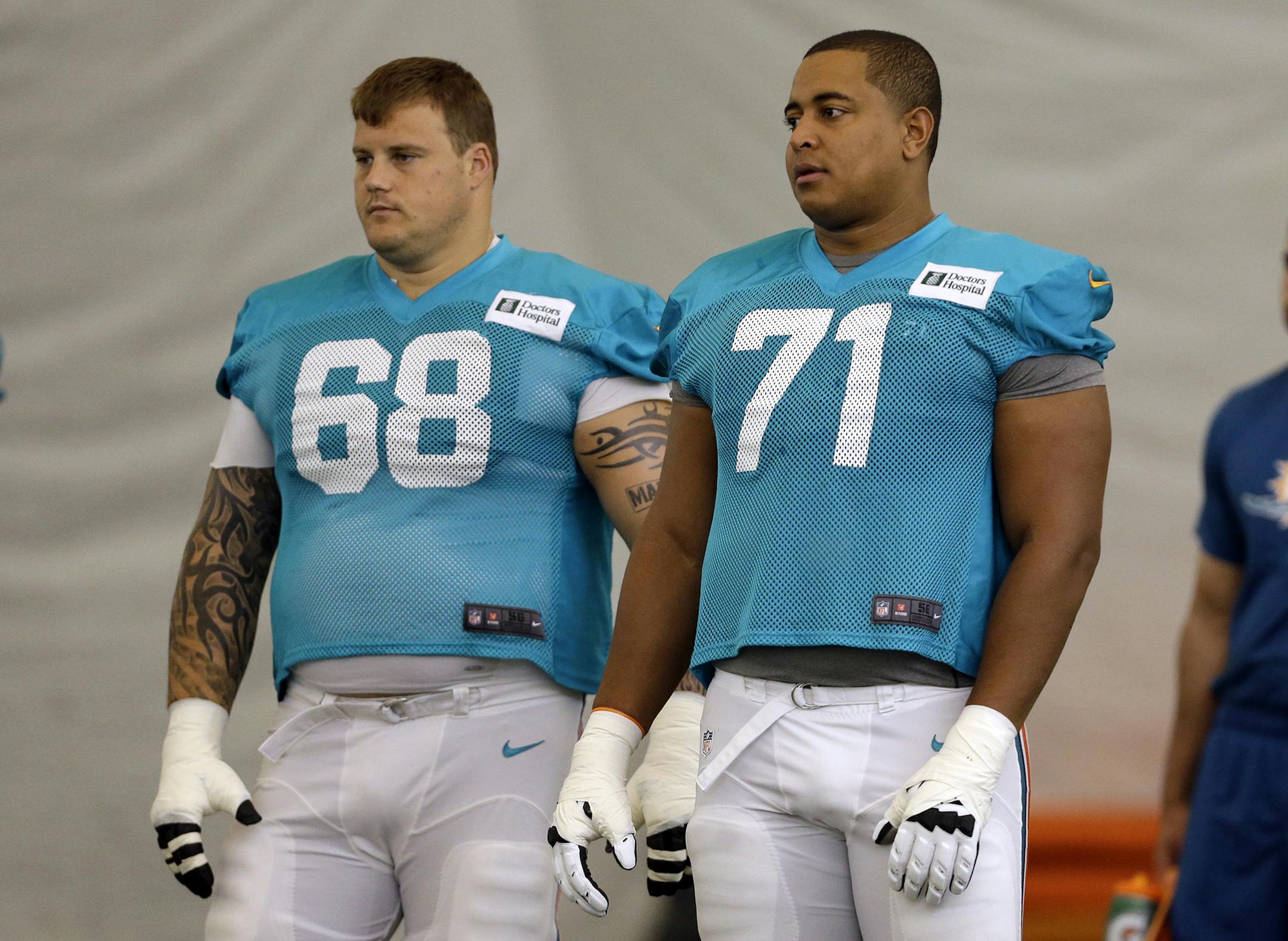 FILE - In this July 24, 2013 file photo, Miami Dolphins guard Richie Incognito (68) and tackle Jonathan Martin (71) stand on the field during an NFL football practice in Davie, Fla.