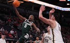 Michigan State guard and former Cretin-Derham Hall standout Tre Holloman (5) takes a shot out of Purdue star Zach Edey's reach Friday at Target Center