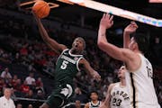 Michigan State guard and former Cretin-Derham Hall standout Tre Holloman (5) takes a shot out of Purdue star Zach Edey's reach Friday at Target Center
