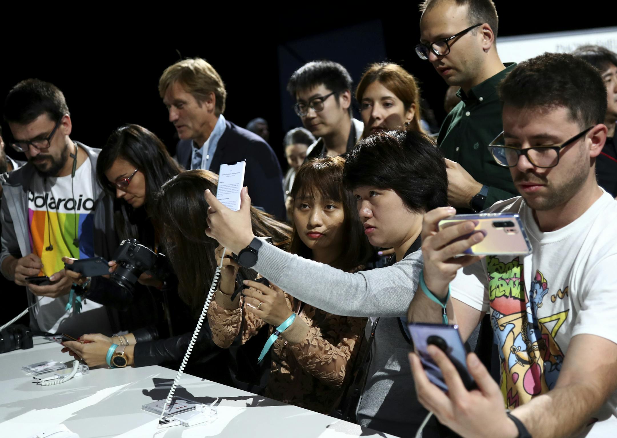 Visitors take pictures of new devices of China's smartphone manufacturer Huawei during an event in Munich, Germany, Thursday, Sept. 19, 2019. (AP Photo/Matthias Schrader) ORG XMIT: RSOB107