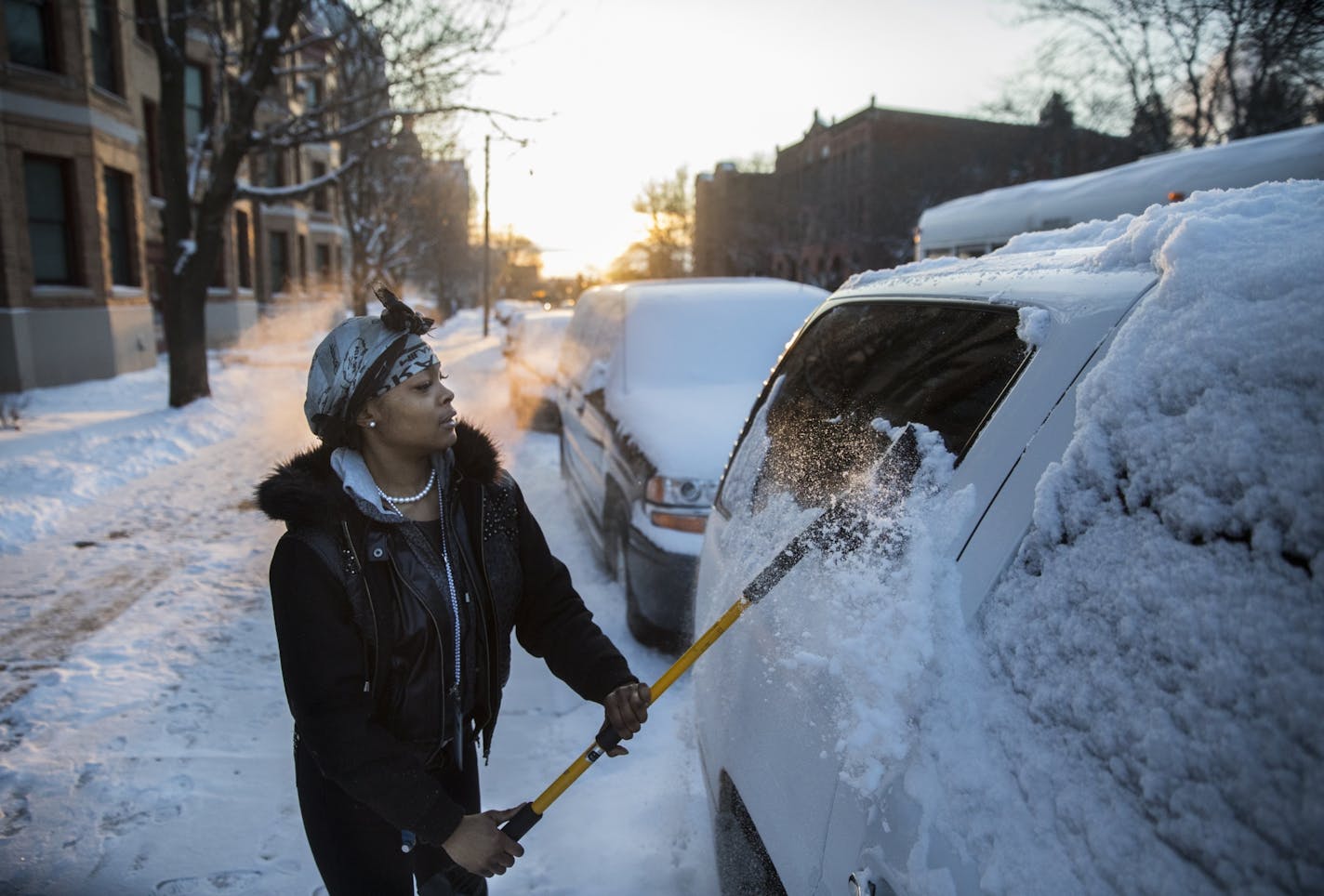 Shae Fowler clears her car of snow in St. Paul before heading to work Monday morning.