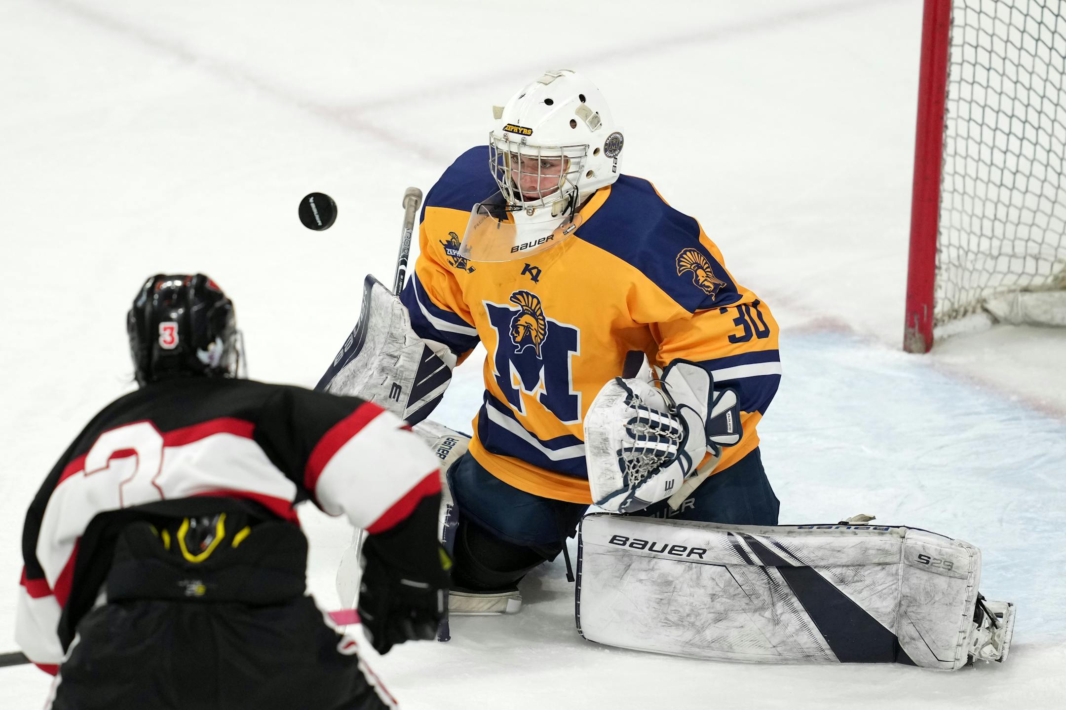 Mahtomedi goaltender Charles Brandt (30) stops a shot by Alexandria forward Leonard Kompelien (3) in the third period of a MSHSL Class 1A quarterfinal hockey game between Alexandria and Mahtomedi.