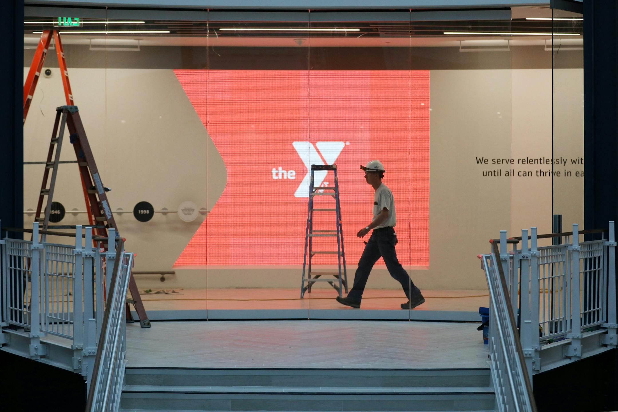 A construction worker walked past the YMCA's glowing logo in the main entrance area.